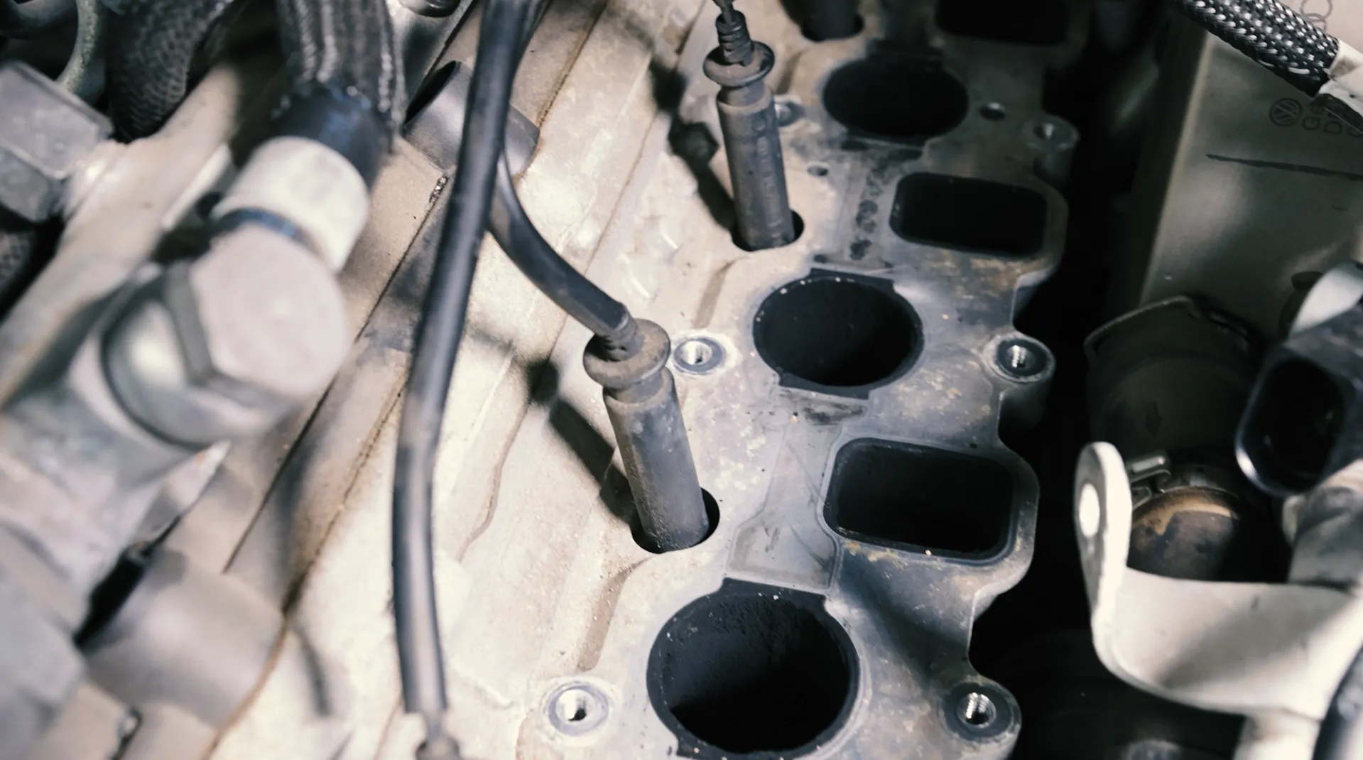 Verkokte Ansaugbrücke mit Einlasskanälen an einem geöffneten Motor in der Werkstatt von Kfz-Technik Stumpf